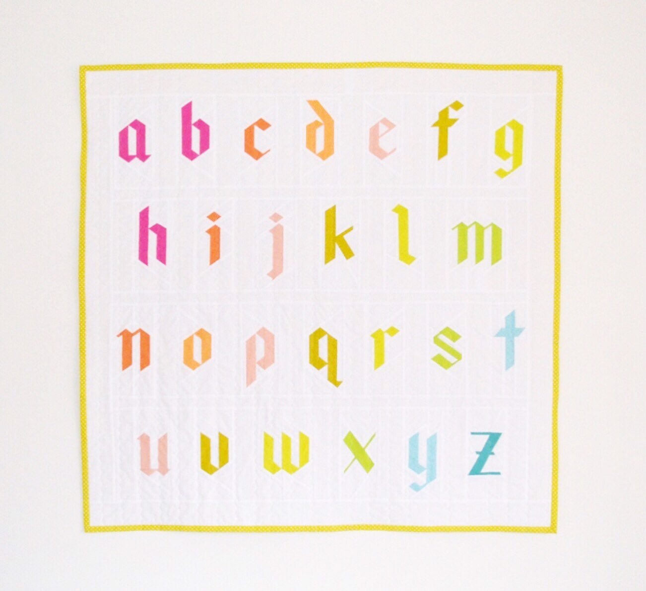 Blackletter alphabet quilt blocks showing  lowercase letters A through Z